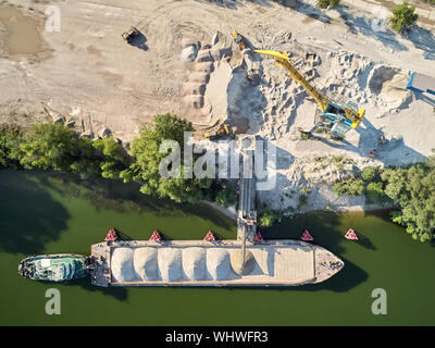 Kran geladen wird Sand und Kies auf binnenschiff Schiff für die Binnenschifffahrt. Antenne drone Stockfoto