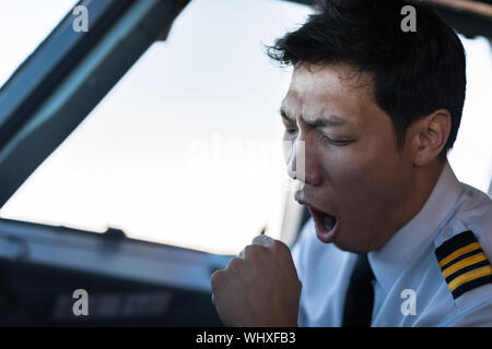 Ein müdes Gähnen Mitarbeiter während der Arbeit. Stockfoto
