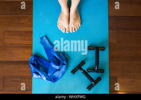 Von oben nach unten Blick einer Frau, Yoga/Pilates mit Pushup bars und Widerstand Bands zu tun Stockfoto