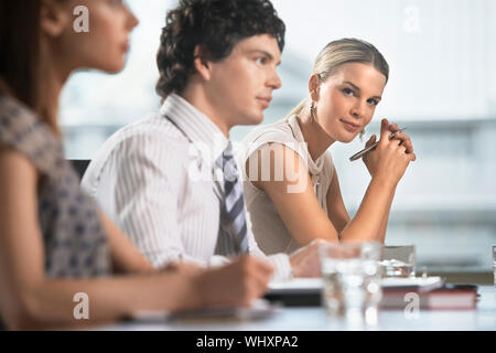 Drei junge Kolleginnen und Kollegen zu einem business Meeting sitzen Stockfoto