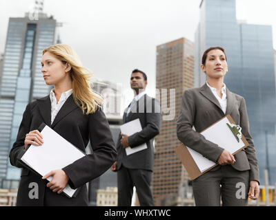 Low Angle View von drei multiethnischen Geschäftsleute mit clipboards außerhalb der Gebäude Stockfoto