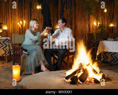 Mann und Frau toasten der Outdoor Nachtclub in der Nähe von bonfire Stockfoto