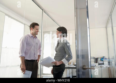 Happy Geschäftsmann und Geschäftsfrau mit Papierkram in Office Stockfoto