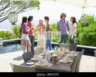 Eine Gruppe von Freunden einen Drink zu genießen und in der Nähe der feine Tisch auf der Terrasse Stockfoto