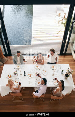 Hohen winkel Portrait von Multiethnischen Freunde toasten Wein zum Abendessen Partei Stockfoto