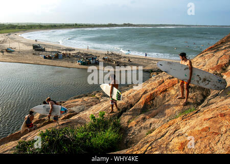 Eine Gruppe von Surfern hinabsteigen Elephant Rock in Arugam Bay in Sri Lanka in Richtung Strand für eine Surf Session. Stockfoto