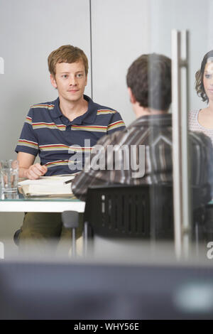 Die Führungskräfte sitzen um Konferenztisch Stockfoto