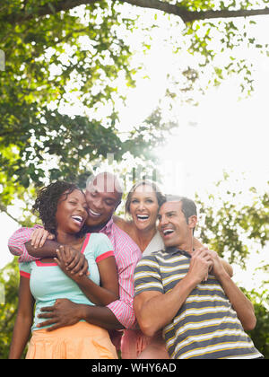 Zwei fröhliche multiethnischen Paar umarmen und Lachen im Garten Stockfoto