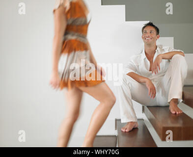 Junger Mann zu Frau auf Treppe im Haus Stockfoto