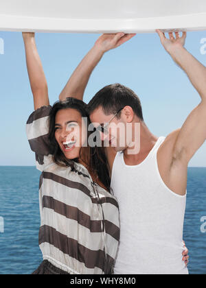 Fröhlicher junger Paare tanzen auf der Yacht mit dem Meer im Hintergrund Stockfoto