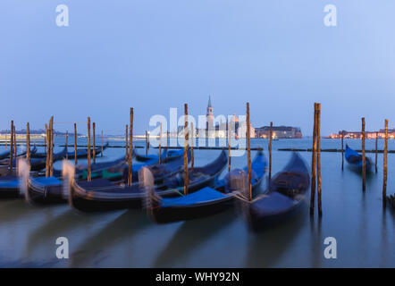 Gondelstation am Canal Grande zur blauen Stunde mit Blick auf die Kathedrale von Saint Giorgio Maggiore, den Markusplatz, Venedig, Venetien, Italien. Stockfoto