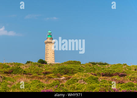 Leuchtturm am Cap Frehel und die Felder, die mit einem violetten Blüten gegen den blauen Himmel im Sommer abgedeckt. Bretagne, Frankreich Stockfoto