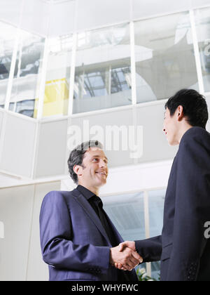 Low Angle View von zwei Geschäftsmänner Hände schütteln im Büro atrium Stockfoto