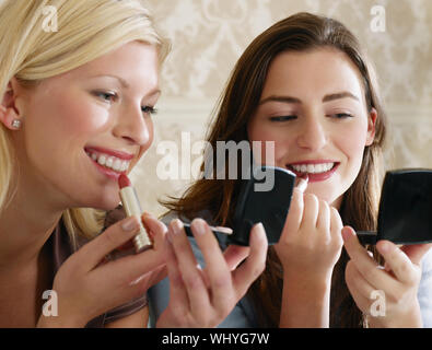 Nahaufnahme von zwei schönen jungen Frauen setzen auf Make-up Stockfoto
