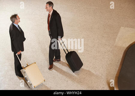 Erhöhten Blick auf zwei Geschäftsmänner mit Koffern durch Gepäckkarussell im air Lobby Stockfoto