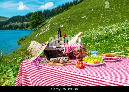 schmeckte Picknick auf dem Rasen in der Nähe von einem See Stockfoto