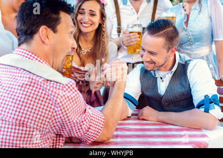 Bayerische Freunde üben die hohe Kunst der Arm Wrestling Stockfoto