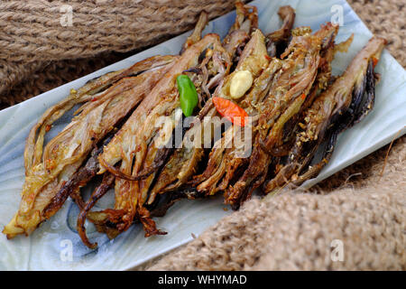 Hohe Aussicht auf hausgemachte Vietnamesischen vegan frittierte Speisen auf dem Teller, Bananen Blüte Braten mit gehackten Zitronengras, Salz und Chili Stockfoto