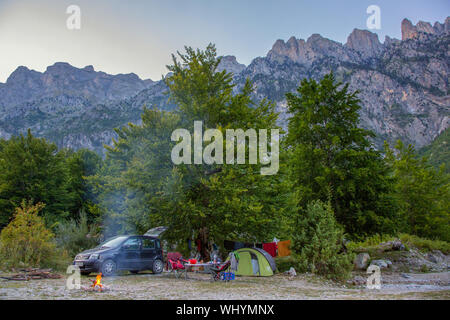 Camping in Valbona Tal mit Zelt und Lagerfeuer vor der majestätischen Albanischen Alpen, nördlichen Albanien Stockfoto