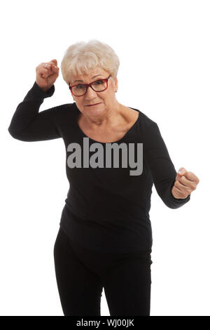 Attractvie alte Frau mit geschlossenen Fäusten. Isoliert auf weiss. Stockfoto