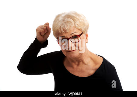 Attractvie alte Frau mit geschlossenen Fäusten. Isoliert auf weiss. Stockfoto