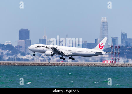 September 1, 2019 Burlingame/CA/USA - Japan Airlines Flugzeug Landung am San Francisco International Airport, Downtown San Francisco Skyline visib Stockfoto