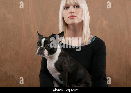 Porträt der schönen jungen Frau mit Französische Bulldogge auf farbigem Hintergrund Stockfoto