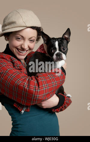 Portrait von lächelnden jungen Frau mit Französische Bulldogge auf farbigem Hintergrund Stockfoto