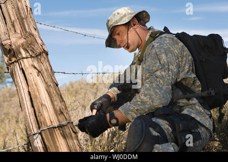 Soldat schneiden Stacheldrahtzaun Stockfoto