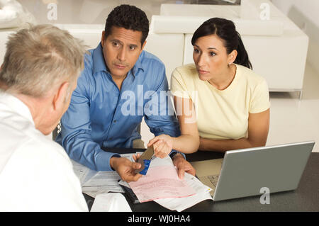 Paar, Dokumenten und Kreditkarten zu Finanzberater über eine Sitzung Stockfoto