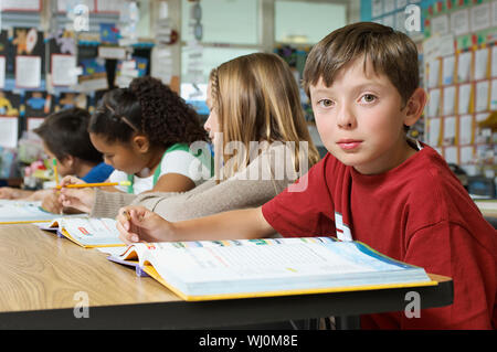 Schüler sitzen in der Klasse und Kamera Stockfoto
