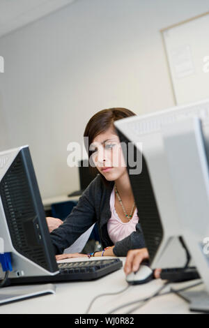 Schöne junge Studentin mit Computer im Labor Stockfoto