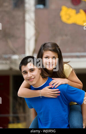 Portrait des jungen Mannes geben piggyback Ride zu Frau an collage Campus Stockfoto