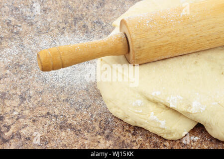 Nahaufnahme von Brotteig wird auf einem Stein Zähler nach oben gerollt. Stockfoto