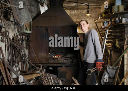 Portrait von zuversichtlich Schmied steht die Schmiede in der Werkstatt Stockfoto