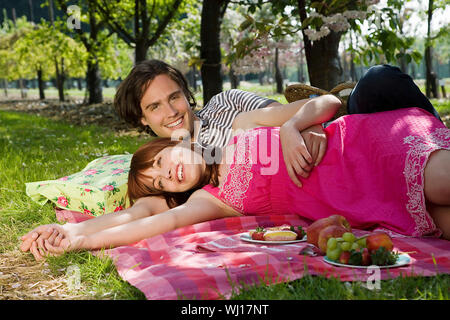 Portrait von lächelnden jungen Paar beim Picknick im Park Stockfoto