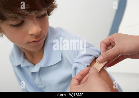 Krankenschwester Platzierung Bandage am Arm des jungen, Nahaufnahme Stockfoto