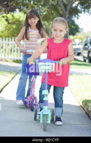 Volle Länge von zwei lächelnde junge Mädchen auf Motorroller Stockfoto