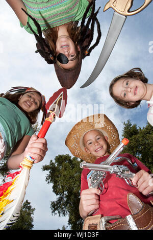 Low Angle Portrait von glücklichen vier Kinder in Kostümen gegen den Himmel Stockfoto