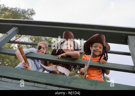 Low Angle View von drei Kinder in Kostümen durch hölzerne Geländer suchen Stockfoto