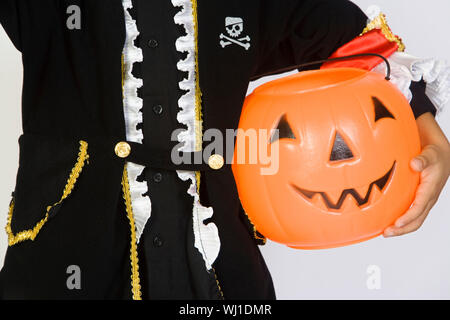 Mittelteil eines Jungen im Halloween outfit Holding Kürbis Eimer über weißem Hintergrund Stockfoto