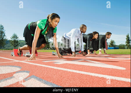 Low Angle View der multiethnischen Geschäft Leute an Startposition auf Rennstrecke Stockfoto