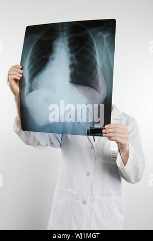 Im mittleren Alter weiblich Krankenschwester Holding x-ray Bericht auf weißem Hintergrund Stockfoto