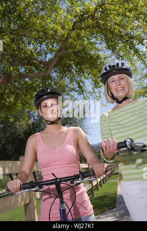 Porträt einer wunderschönen Großmutter und Enkelin sitzen auf Zyklus tragen Helm Stockfoto