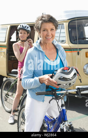 Portrait der glücklichen Mutter und Tochter tragen Helm mit RV im Hintergrund Stockfoto