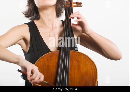 Mittelteil einer weiblichen Cello spielen klassische Musik Instrument auf weißem Hintergrund Stockfoto