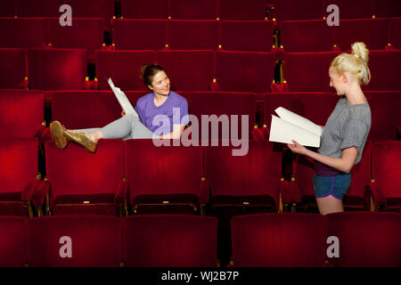 Zwei junge Frauen im Theater sitzen mit Skripten Abschaltdruck Stockfoto