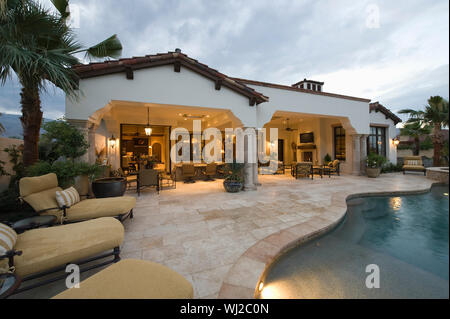 Blick auf Sonnenliegen am Pool gegen moderne Home Stockfoto