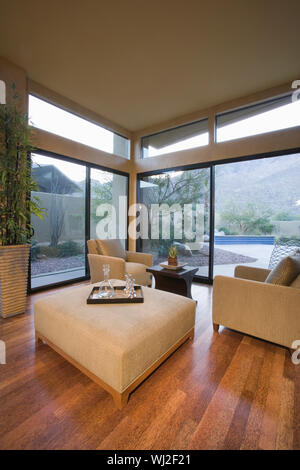 Polstermöbel in Wohnzimmer mit Fenstern vom Boden bis zur Decke Stockfoto