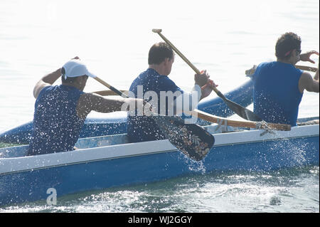 Männlichen Ruderer paddeln Outrigger Kanu im Rennen Stockfoto